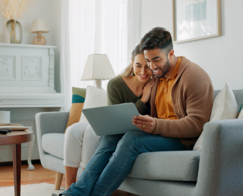 Couple reviewing homebuying options on a laptop while planning their future together