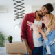 Young couple unpacking boxes in their new home, symbolizing a hopeful start to homeownership.